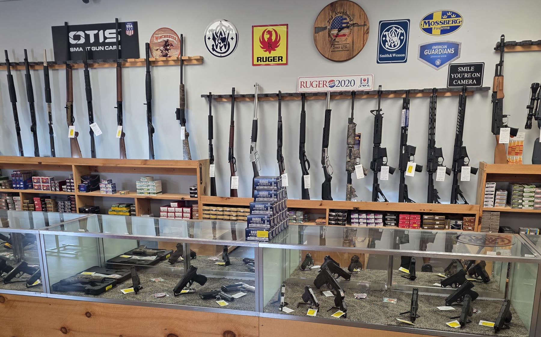 Inside a 2A Guns & Ammo store: glass cases, wood counters and the long-gun wall